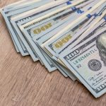 american dollar bills on wooden desk