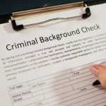 Hand Filling Criminal Background Check Application Form