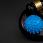 Legality of federal vaccine mandates, covid19 public health crisis and impact of mandatory covid vaccines concept with coronavirus model and judge gavel isolated on black background with copy space