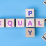 EQUAL PAY text on wooden blocks, daollars on blue background