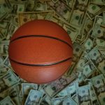 Basketball on a pile of cash -- sports betting concept