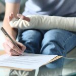 Disabled woman with bandaged arm signing document