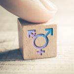 Transgender, LGBT or Intersex Icon On Wodden Block On A Table Arranged By A Finger