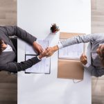 Elevated View Of A Male Manager Shaking Hands With Female Applicant At Workplace