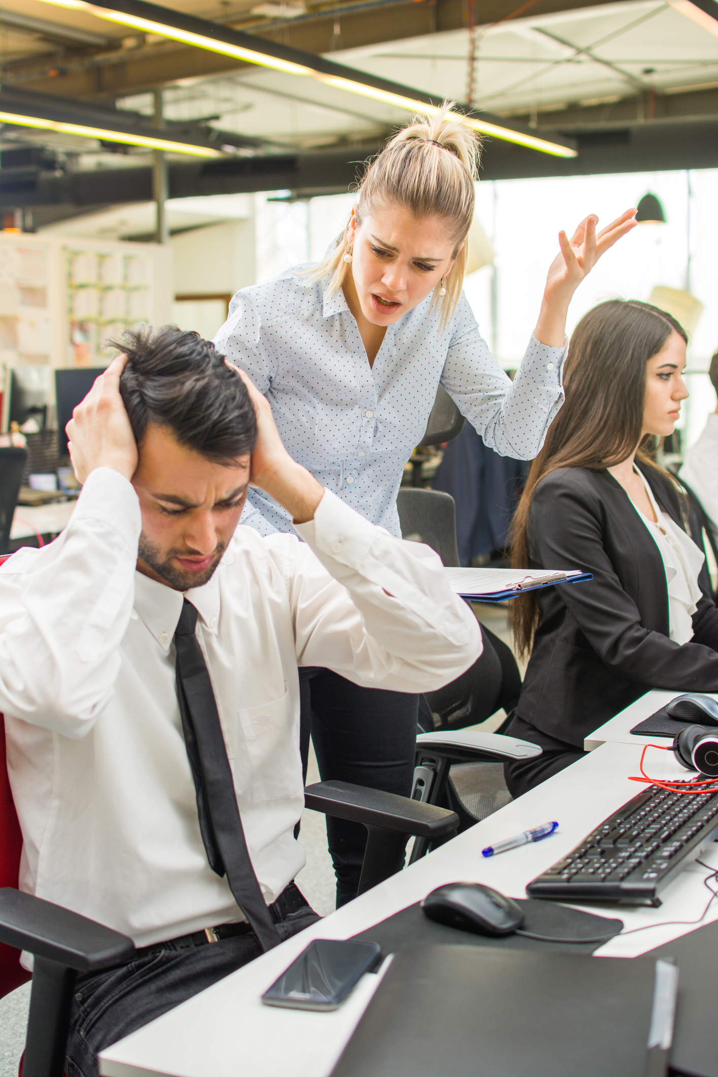 Angry businesswoman shouting to a stressed employee at office.