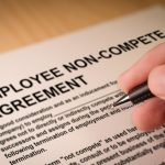 Man signing an employee Non-compete agreement. Selective focus