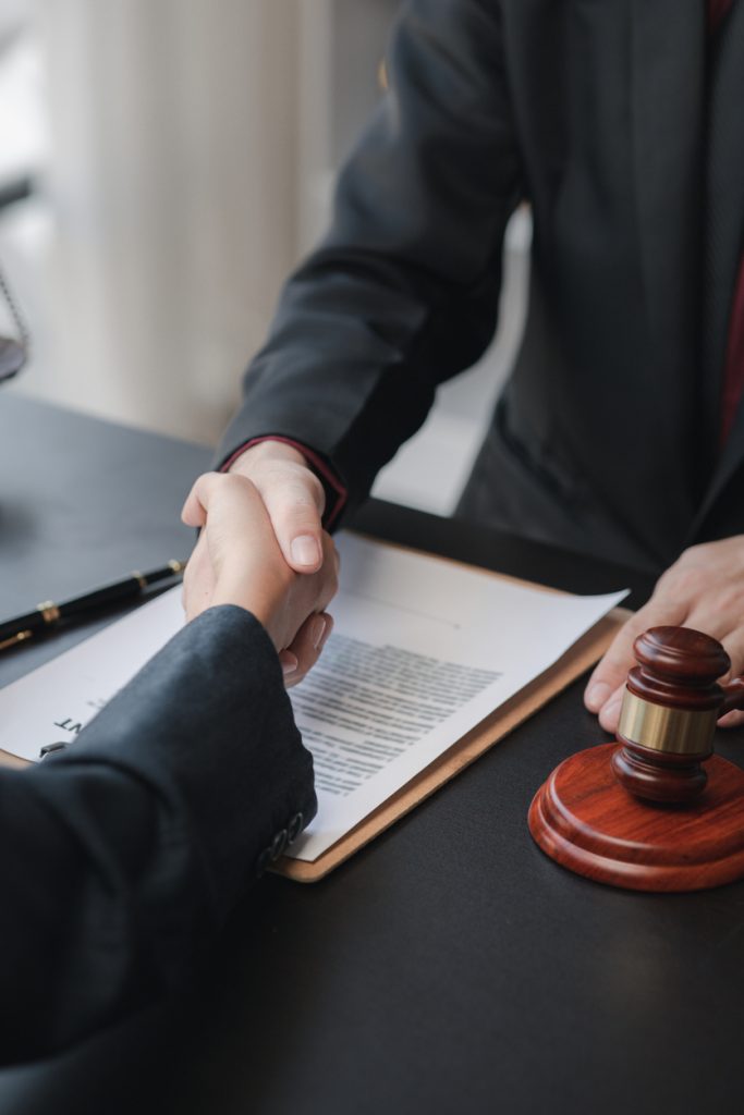 Lawyers shake hands with clients who come to testify in the case of embezzlement from business partners who jointly invest in the business. The concept of hiring a lawyer for legal proceedings.