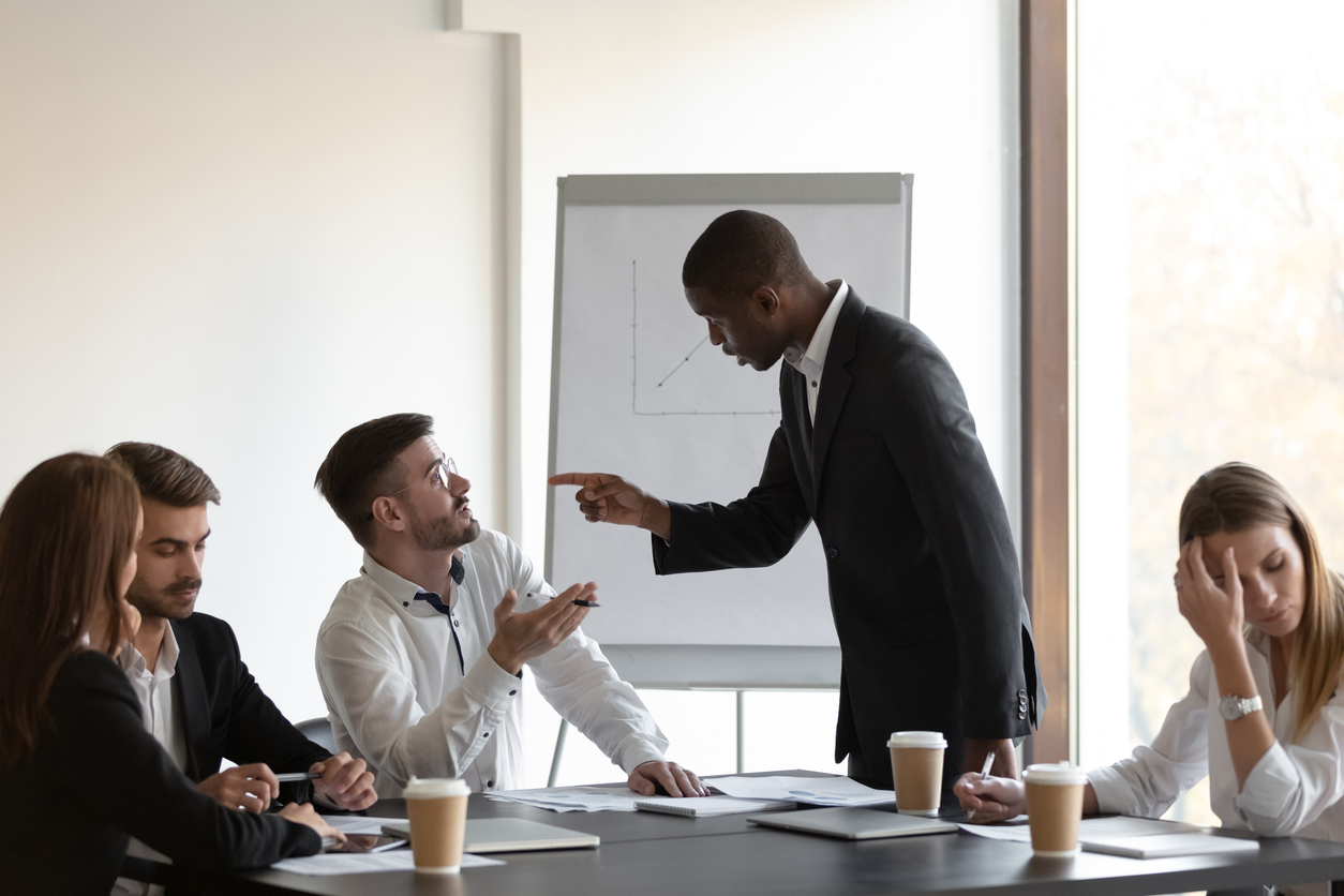 Multi-ethnic business partners having conflict accuse each other at group meeting in boardroom unpleasant situation caused by personal dislike, racial discrimination, struggle for leadership concept